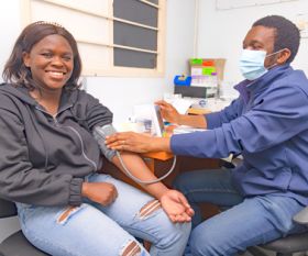 Manase Mapendere checking Nokutula Zimba's blood pressure at Aurum Institute in Tembisa, South Africa. Credit: Mwangi Kirubi/IAVI