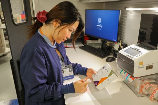 Su Yadana Oo, RPh., pharmacist at the OHSU Home Infusion Clinic pharmacy in Beaverton, checks the package of pre-exposure prophylaxis, or PrEP. PrEP is an antiretroviral medication that reduces the risk of getting HIV from sexual intercourse by about 99%. (OHSU/Christine Torres Hicks)