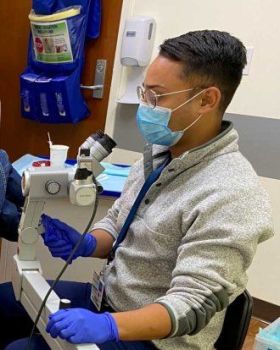 Vasean Patel, a UCSF Nurse Practitioner with ANCRE (Anal Neoplasia Clinic Research and Education), performs a high-resolution anascopy (HRA) exam using an anoscope and colposcope to screen for anal HPV-related disease. Image provided by Vasean Patel